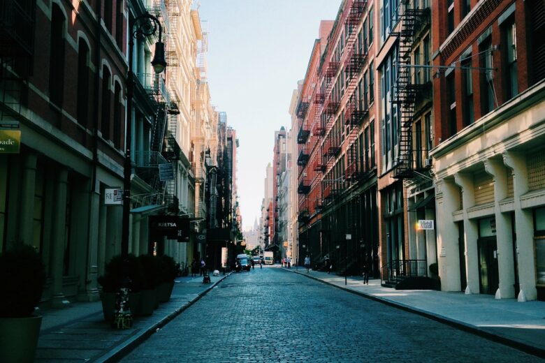 A street with many buildings and some people walking on it