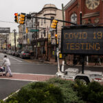 A sign on the side of a road that says covid 1 9 testing.