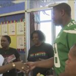 People shaking hands at community event.