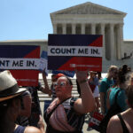 Protesters holding "Count Me In" signs outside.