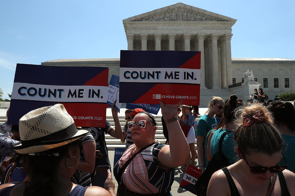 Protesters holding "Count Me In" signs outside.