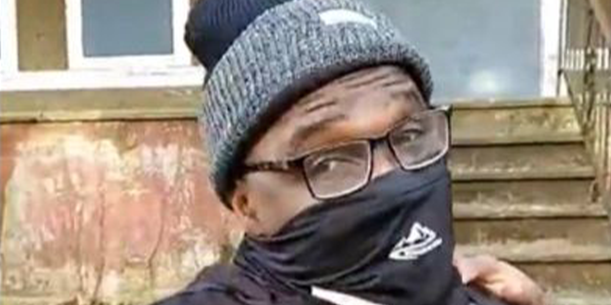 A man wearing glasses and a hat with a face mask on.
