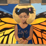 Girl with butterfly wings mural, "Love" written.