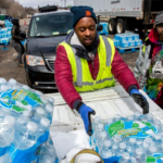 Volunteers distributing bottled water from truck.