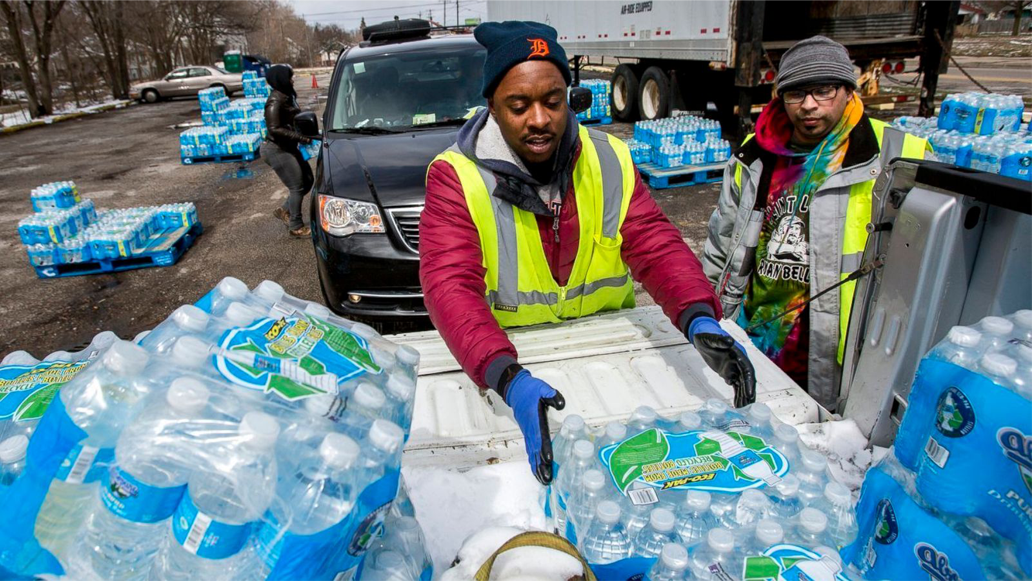 Volunteers distributing bottled water from truck.