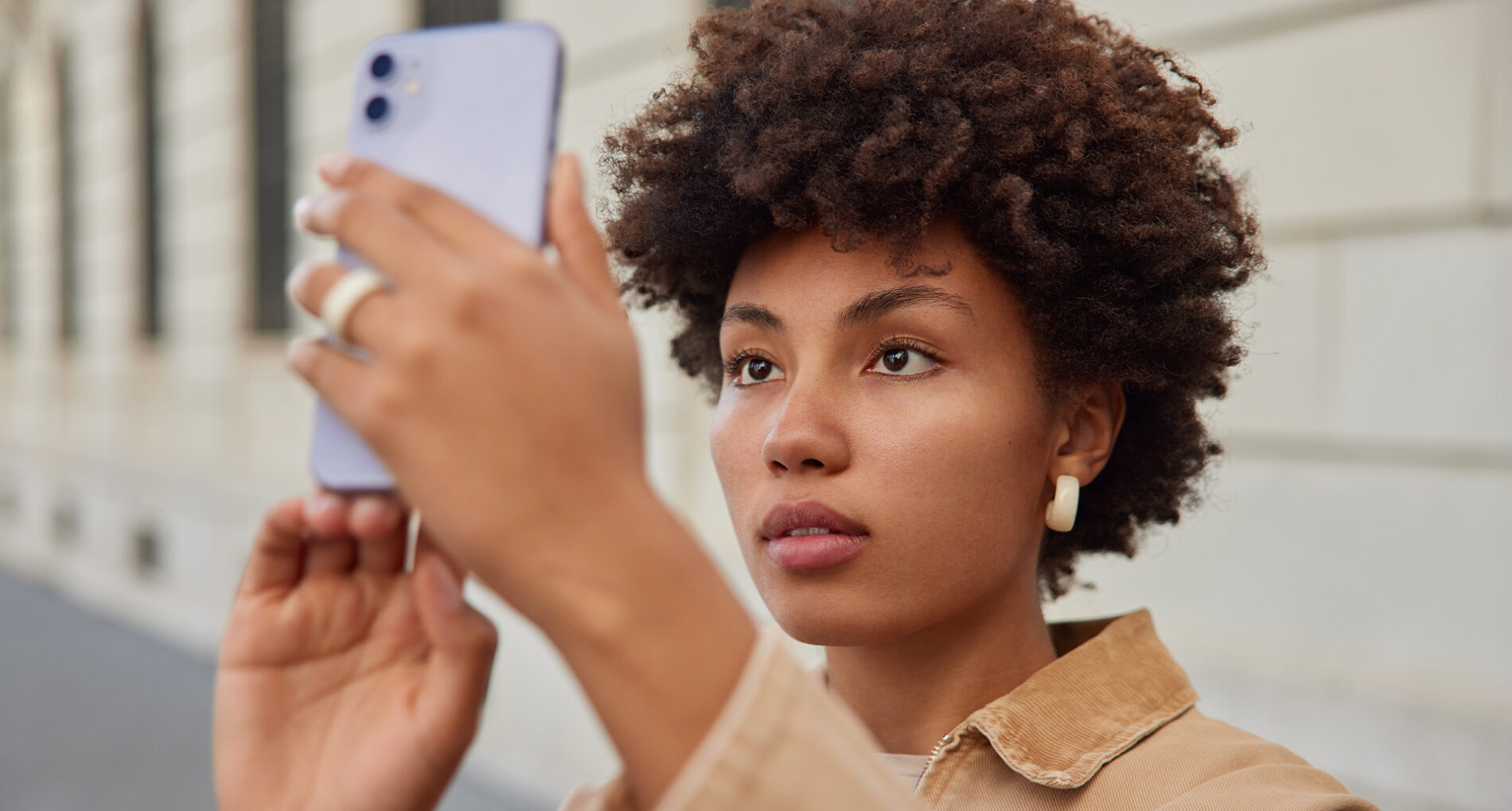Woman taking a photo with smartphone outdoors.